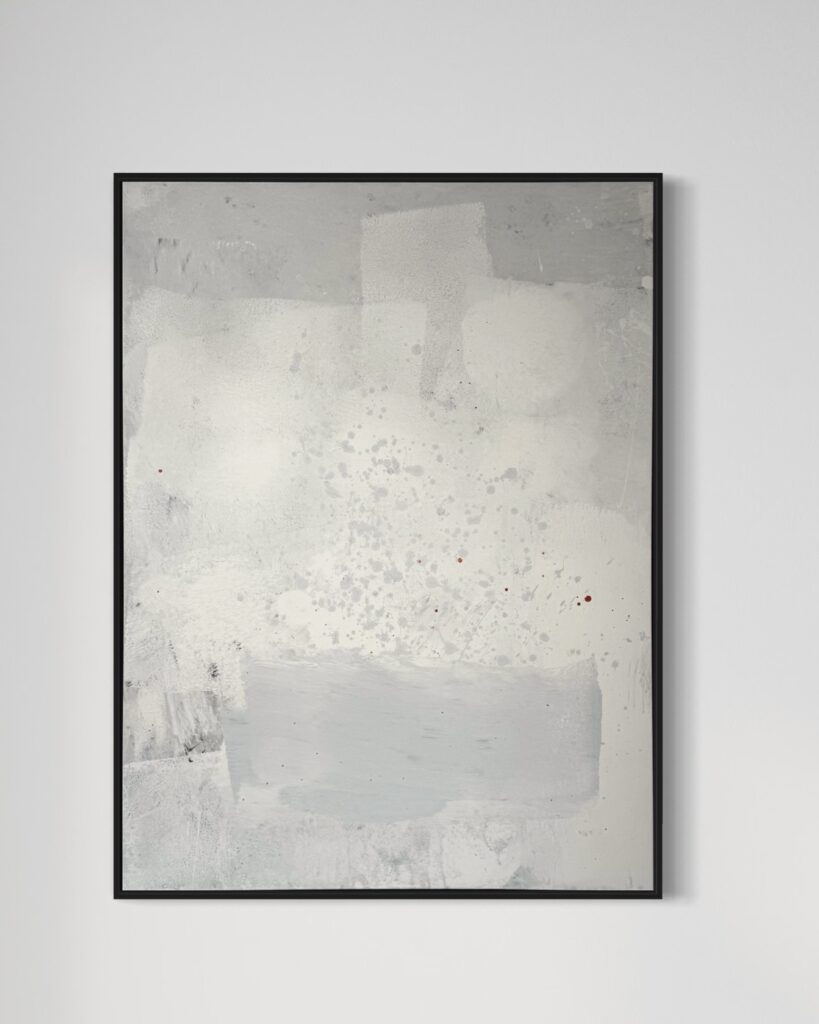 An abstract painting titled "White Bloom" by Gina Keatley, featuring layers of muted whites, soft grays, and delicate textures that evoke the organic unfolding of petals. The canvas is enriched with faint crackling, soft brushstrokes, and Keatley’s signature speckled, rain-like drips scattered throughout. Subtle touches of mandarin orange punctuate the calm composition, adding warmth and contrast within the monochromatic palette. The piece is framed in a sleek black border, enhancing its minimalist, refined presentation.